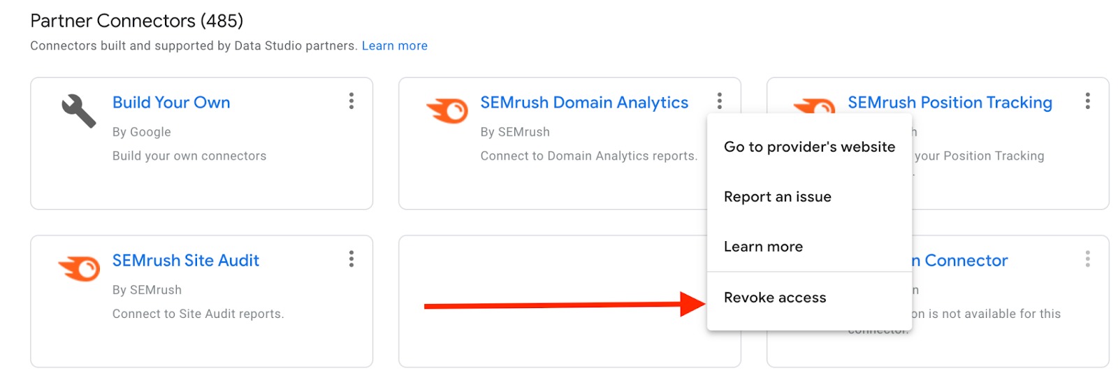 Partner Connectors list in Looker Studio settings. Screenshot features a dropdown menu that appears after clicking on three dots icon next to a connector name. A red arrow is pointing at the last option available in this dropdown menu, 'Revoke access'.